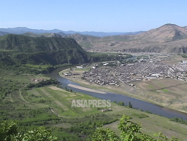 豆満江を挟んで左側が中国、右側の北朝鮮の山には見事に木がない。2004年6月咸鏡北道茂山（ムサン）郡。中国側から石丸次郎撮影（アジアプレス）